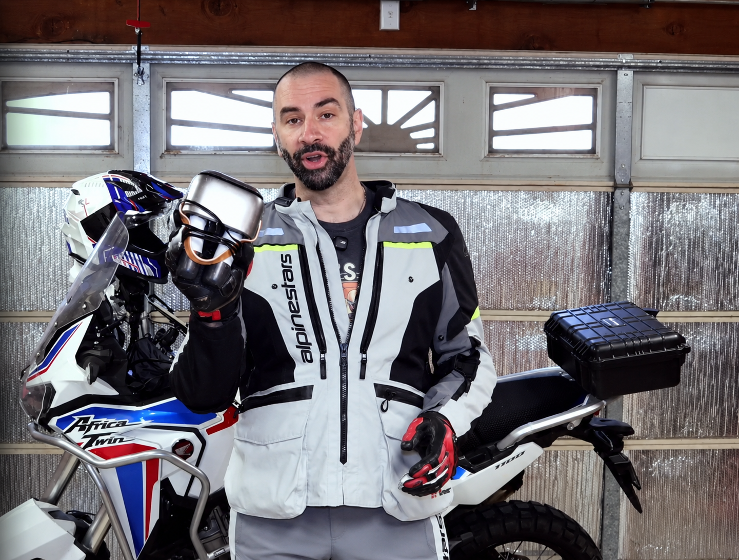 Creator holding the SOTHING Ultra Boot Dryer beside a motorcycle